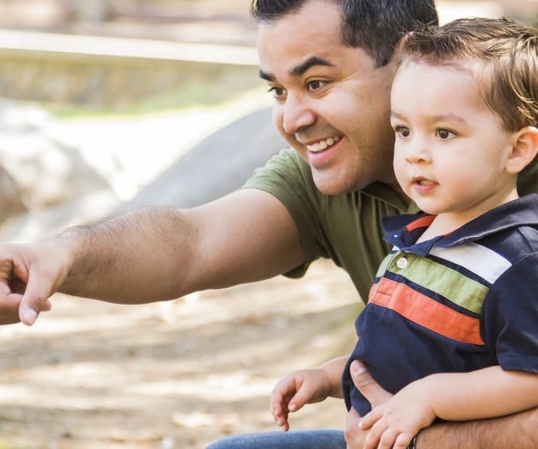 A Latino father with his young son in the park