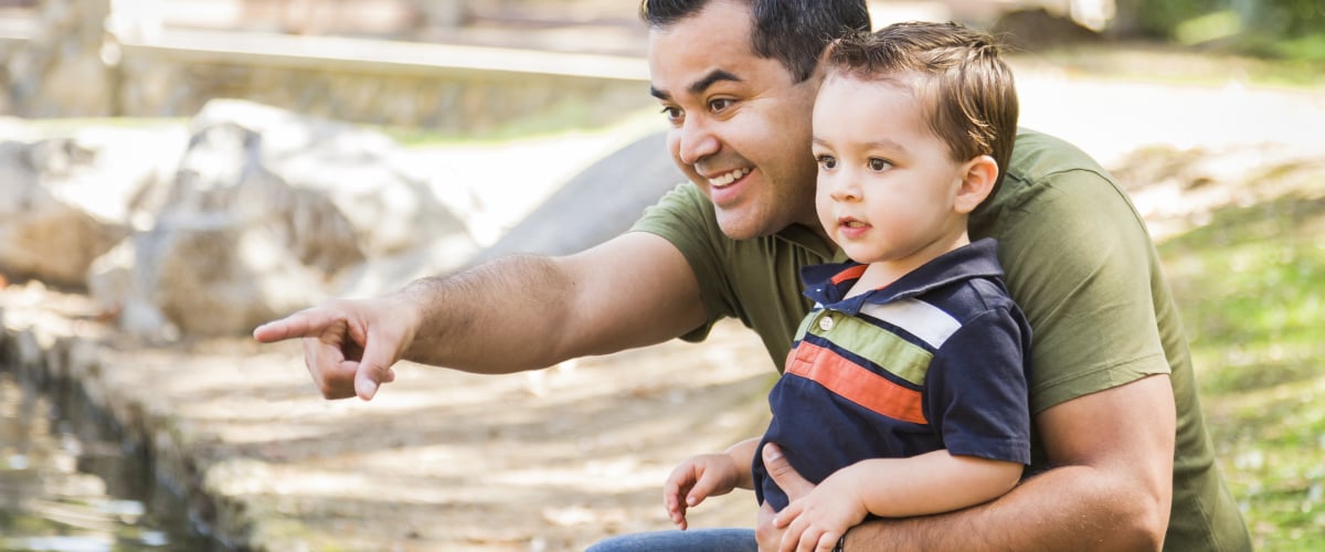 A Latino father with his young son in the park