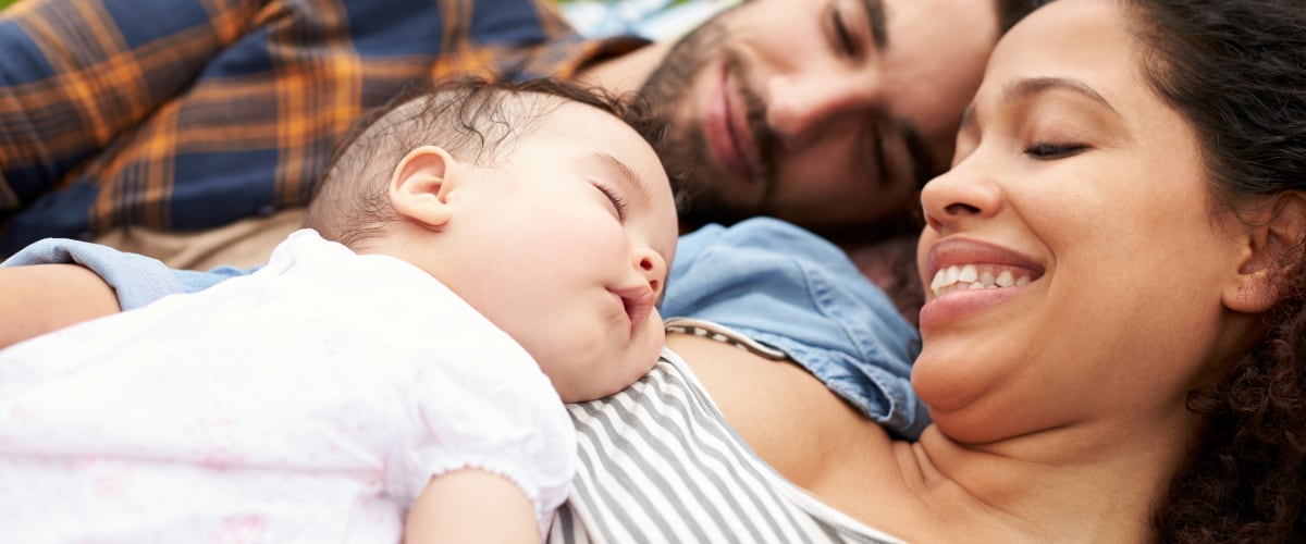 Mixed-race parents holding their infant