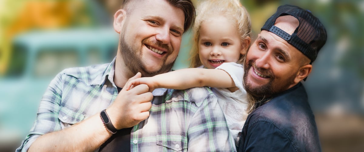 Two dads with their daughter