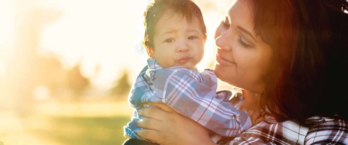 A young mother holds her infant son